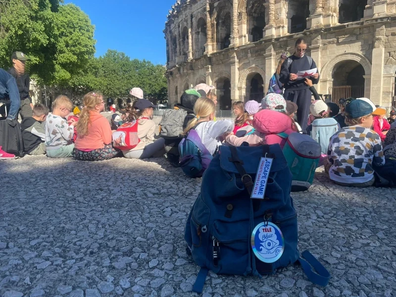 Sac à dos d'enquête Télé Bleue devant les arènes